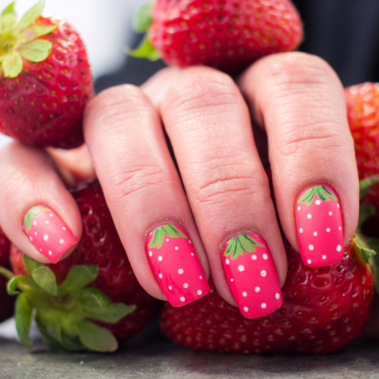 Een hand met kleurrijke nagels versierd met levendige fruitpatronen zoals aardbeien, citroenen, watermeloenen en kersen, voor een speelse en zomerse uitstraling